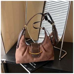 Détail du sac lune marron avec texture en daim et boucle dorée en forme de croissant