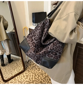 Detail view of leopard print tote bag with black leather stitching and white seam detail