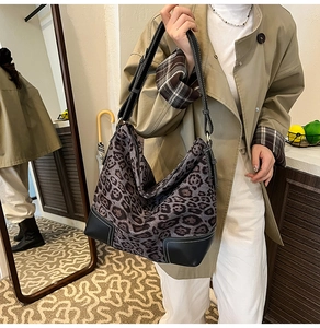 Detail view of leopard print tote bag with black faux leather trim and contrast stitching