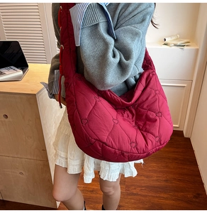 Close-up of heart embroidered quilted texture on burgundy large capacity nylon shoulder bag