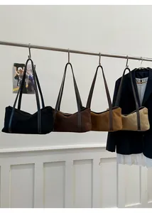 Macro shot of minimalist suede tote bags in four neutral tones hanging on a rack