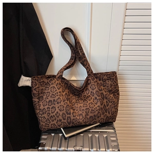 Close-up of leopard print canvas tote bag placed on a suitcase for commuting and travel