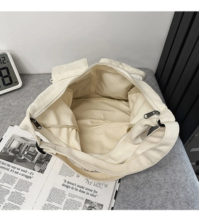 Vue intérieure du cabas en toile beige avec deux poches ouvertes et fermeture éclair noire