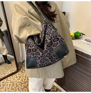 Close-up of leopard print tote with black leather trim and white contrast stitching detail