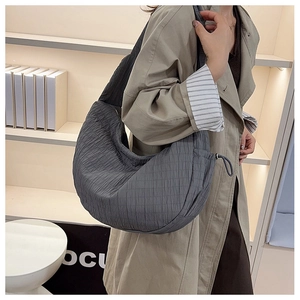 Macro shot of the grey pleated tote bag showing vertical quilted texture and soft fabric