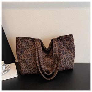 Detail of the leopard print canvas tote bag showing the textured fabric and dual handles