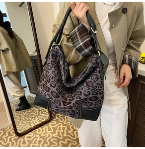 Detailed view of leopard print hobo bag with black leather corners and white stitching