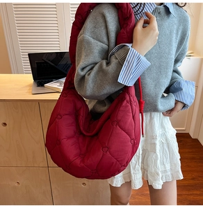 Detail of the oversized quilted dumpling bag with heart patterns in burgundy red finish