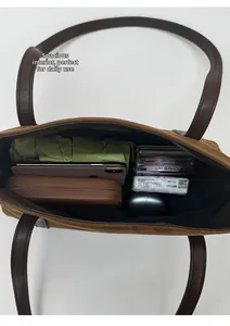 Detail view of brown suede tote bag interior showing spacious storage for daily items