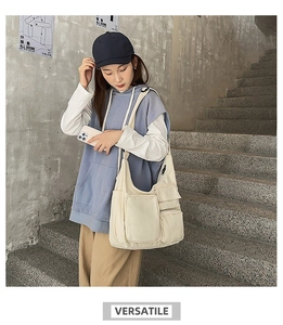 Vue détaillée du sac bandoulière en toile crème avec poches fonctionnelles sur escalier