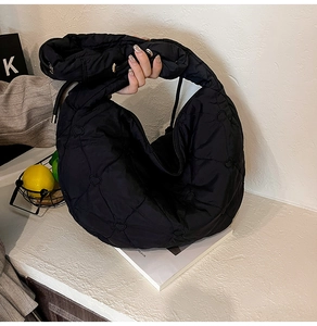 Detail of black heart-quilted puffer tote bag with durable nylon texture for daily commute
