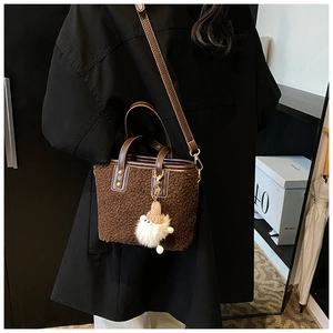 Detailed close-up of brown plush bucket bag showing soft texture and leather handle