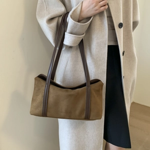 Detail view of brown suede underarm bag with sleek leather straps for daily commute