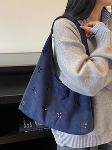 Sac fourre-tout en daim bleu foncé avec motif floral découpé au laser porté à l'épaule