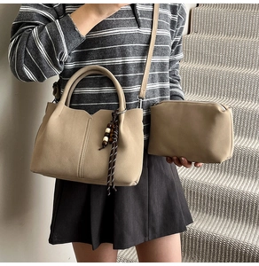 Detail view of khaki bucket bag with wave cut edge and stylish wooden bead tassel