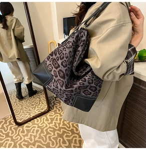 Detailed shot of leopard print tote bag with black leather corners and white stitching