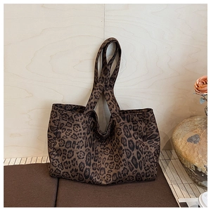 Close-up of leopard print canvas tote bag on cushion with elegant flower background