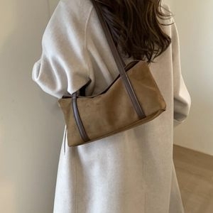 Detail of a brown suede shoulder bag showing the premium texture and minimalist vintage design