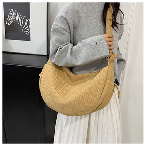 Close-up of pleated drawstring mustard crescent bag with unique quilted texture details