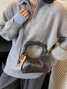 Minimalist black crescent dumpling bag with pleated handle and metallic chain strap