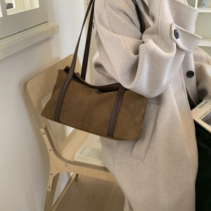 Detail view of a vintage dark brown suede tote bag worn over the shoulder for daily commute