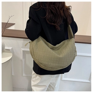 Detailed view of olive green quilted hobo bag with drawstring and wide shoulder strap