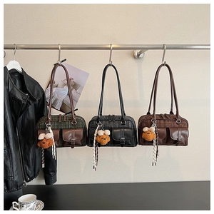 Detailed close-up of retro plaid Boston bags in green, black, and brown with leather pockets