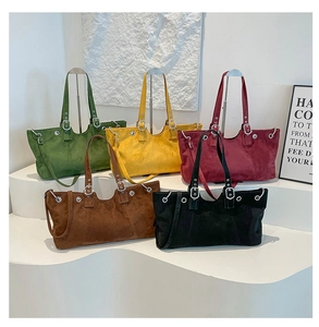 Detail view of colorful matte leather tote bags in green, yellow, burgundy, coffee, and black