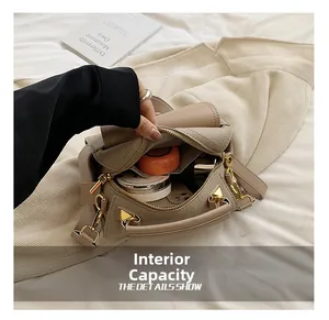 Capacità interna della borsa in pelle beige con cosmetici e dettagli dorati