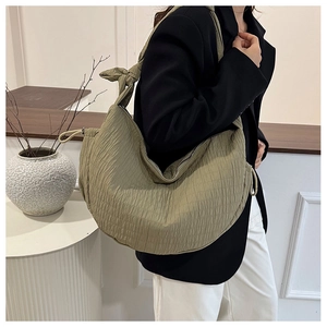 Detail of olive green pleated hobo bag with knotted shoulder strap and zipper closure