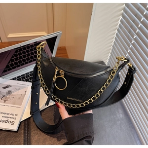 Détail du sac selle en similicuir noir avec grosse chaîne dorée et logo de marque