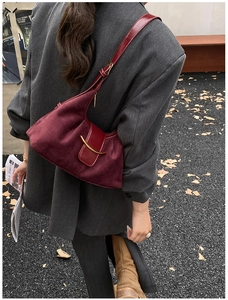 Détails du sac fourre-tout en daim bordeaux avec fermoir doré en forme de lune et coutures