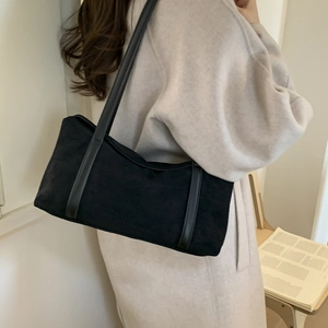 Close-up of black suede pillow bag showing premium matte texture and shoulder straps