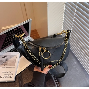 Vue détaillée du sac selle en cuir grainé noir avec chaîne dorée et double fermeture éclair