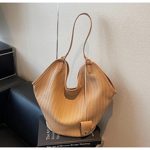 Detail of light brown woven hobo tote bag with herringbone texture and small pouch