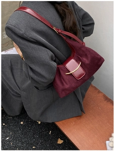 Détail du sac vintage bordeaux avec boucle dorée sur daim et cuir de haute qualité