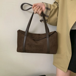 Detailed macro of dark brown suede pillow bag with vintage long leather handles