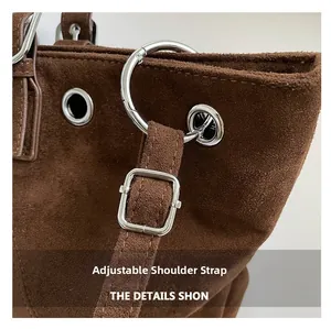 Close-up of adjustable strap and silver metal hardware on brown suede tote bag