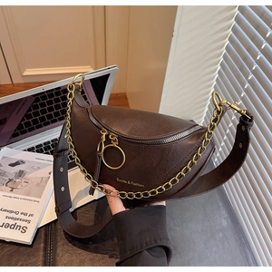 Vue détaillée du sac selle en cuir mat marron avec chaîne dorée et zip métallique rond