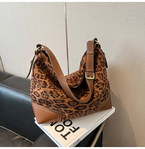 Macro shot of leopard print tote bag detailing leather corners and golden buckle