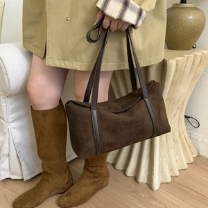Detail of vintage dark brown suede pillow bag with matching leather handle for women
