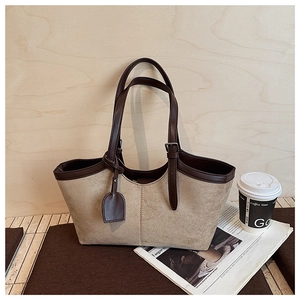 Detail of khaki suede tote bag with contrast brown leather trim and wavy top edge