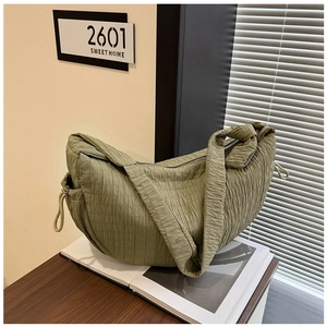 Close-up of olive green pleated tote bag showing fabric texture and drawstring detail