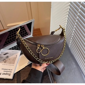 Détail d'un sac selle marron foncé avec chaîne dorée et double fermeture éclair