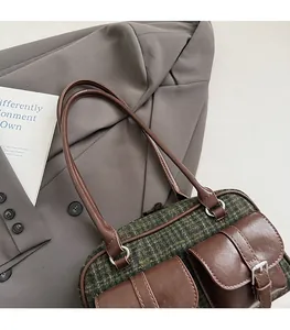 Detailed view of British style plaid bowling bag with brown leather pockets and strap
