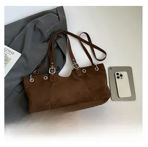 Macro shot of vintage brown suede shoulder bag showing silver eyelets and buckle details