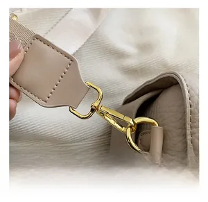 Dettaglio del gancio dorato in metallo e della texture della pelle della borsa
