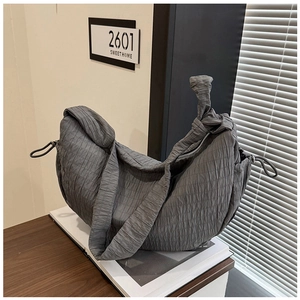 Detail shot of the dark grey pleated fabric texture and drawstring on the crescent bag