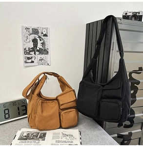 Détail du sac bandoulière en toile avec multiples poches et une large sangle réglable