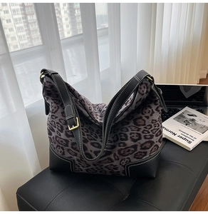 Detail of leopard print tote bag with black leather patchwork and contrast white stitching